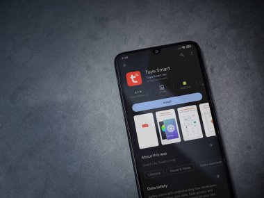 Lod, Israel - July 16,2023: Tuya Smart app play store page on smartphone on a dark marble stone background. Top view flat lay with copy space.