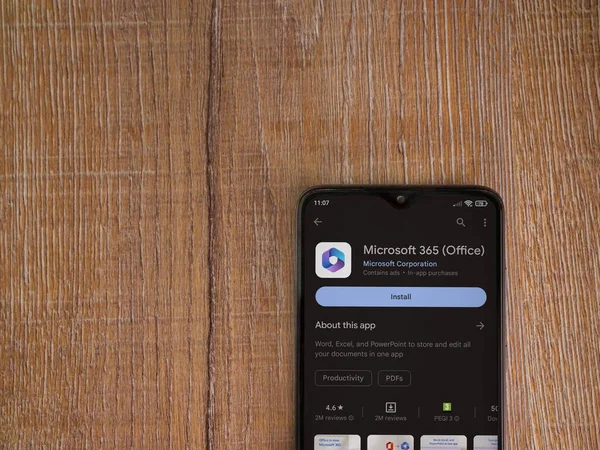 Lod, Israel - July 16,2023: Microsoft 360 app play store page on smartphone on wooden background. Top view flat lay with copy space.