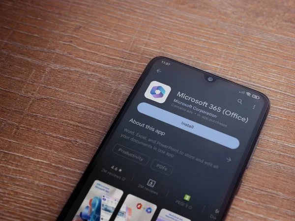 Lod, Israel - July 16,2023: Microsoft 360 app play store page on smartphone on wooden background. Top view flat lay with copy space.