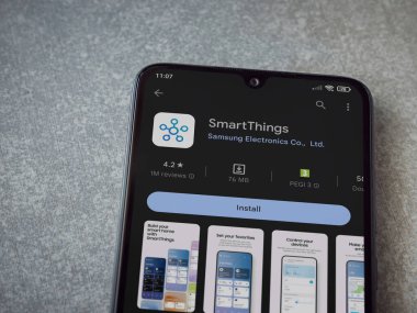 Lod, Israel - July 16,2023: Smartthings app play store page on smartphone on ceramic stone background. Top view flat lay with copy space.