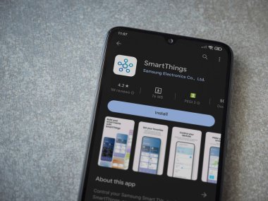 Lod, Israel - July 16,2023: Smartthings app play store page on smartphone on ceramic stone background. Top view flat lay with copy space.