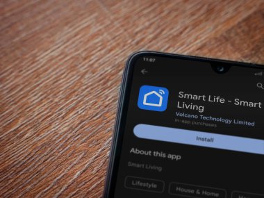 Lod, Israel - July 16,2023: Smart Life app play store page on smartphone on wooden background. Top view flat lay with copy space.
