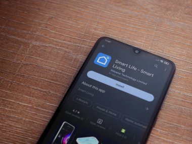 Lod, Israel - July 16,2023: Smart Life app play store page on smartphone on wooden background. Top view flat lay with copy space.