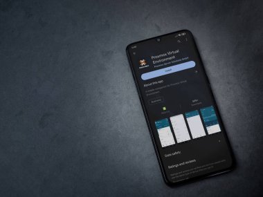Lod, Israel - July 16,2023: Proxmox Virtual Environment app play store page on smartphone on a dark marble stone background. Top view flat lay with copy space.