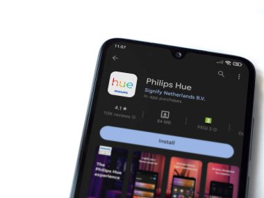Lod, Israel - July 16,2023: Philips Hue app play store page on smartphone on white background. Top view flat lay with copy space.