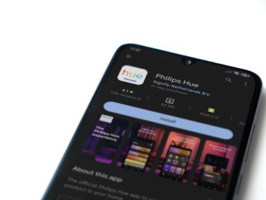 Lod, Israel - July 16,2023: Philips Hue app play store page on smartphone on white background. Top view flat lay with copy space.