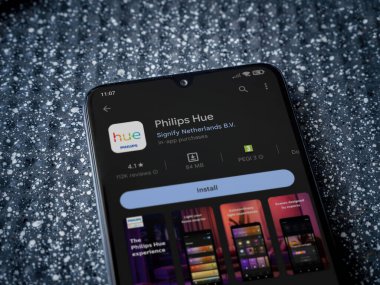 Lod, Israel - July 16,2023: Philips Hue app play store page on smartphone on a metallic background. Close up top view flat lay.