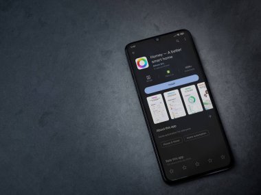 Lod, Israel - July 16,2023: Homey app play store page on smartphone on a dark marble stone background. Top view flat lay with copy space.