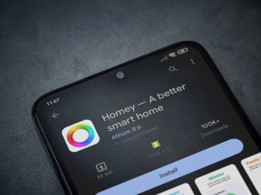 Lod, Israel - July 16,2023: Homey app play store page on smartphone on a dark marble stone background. Top view flat lay with copy space.