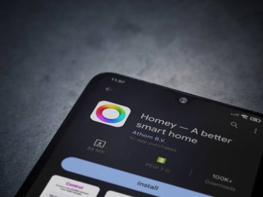 Lod, Israel - July 16,2023: Homey app play store page on smartphone on a dark marble stone background. Top view flat lay with copy space.