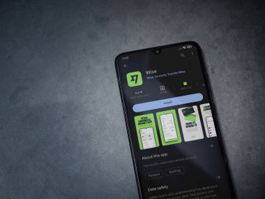 Lod, Israel - July 16,2023: Wise app play store page on smartphone on a dark marble stone background. Top view flat lay with copy space.
