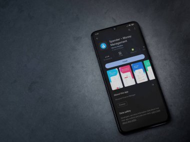 Lod, Israel - July 16,2023: Spender app play store page on smartphone on a dark marble stone background. Top view flat lay with copy space.
