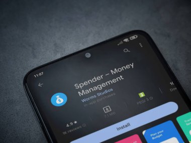 Lod, Israel - July 16,2023: Spender app play store page on smartphone on a dark marble stone background. Top view flat lay with copy space.