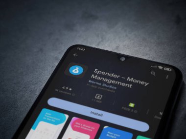 Lod, Israel - July 16,2023: Spender app play store page on smartphone on a dark marble stone background. Top view flat lay with copy space.