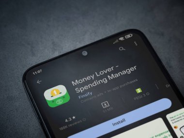 Lod, Israel - July 16,2023: Money Lover app play store page on smartphone on a dark marble stone background. Top view flat lay with copy space.