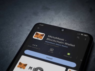 Lod, Israel - July 16,2023: MetaMask app play store page on smartphone on a dark marble stone background. Top view flat lay with copy space.