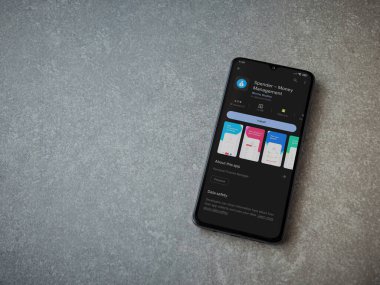 Lod, Israel - July 16,2023: Spender app play store page on smartphone on ceramic stone background. Top view flat lay with copy space.