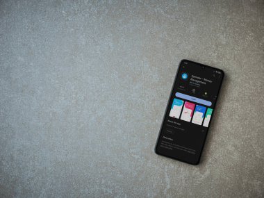 Lod, Israel - July 16,2023: Spender app play store page on smartphone on ceramic stone background. Top view flat lay with copy space.