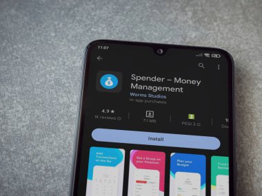 Lod, Israel - July 16,2023: Spender app play store page on smartphone on ceramic stone background. Top view flat lay with copy space.