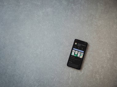 Lod, Israel - July 16,2023: Spendee app play store page on smartphone on ceramic stone background. Top view flat lay with copy space.