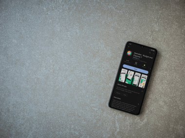 Lod, Israel - July 16,2023: Spendee app play store page on smartphone on ceramic stone background. Top view flat lay with copy space.