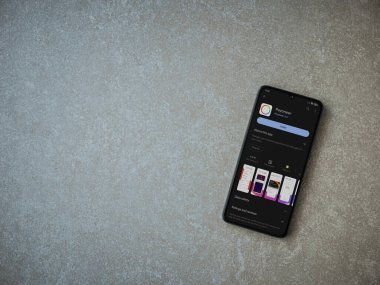 Lod, Israel - July 16,2023: Payoneer app play store page on smartphone on ceramic stone background. Top view flat lay with copy space.