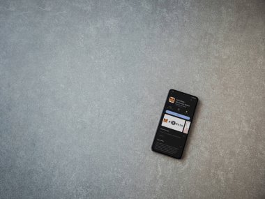 Lod, Israel - July 16,2023: MetaMask app play store page on smartphone on ceramic stone background. Top view flat lay with copy space.