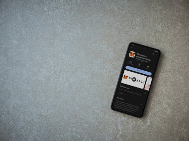 Lod, Israel - July 16,2023: MetaMask app play store page on smartphone on ceramic stone background. Top view flat lay with copy space.