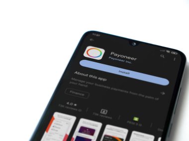 Lod, Israel - July 16,2023: Payoneer app play store page on smartphone on white background. Top view flat lay with copy space.