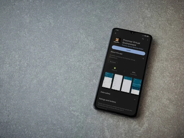 Lod, Israel - July 16,2023: Proxmox Virtual Environment app play store page on smartphone on ceramic stone background. Top view flat lay with copy space.