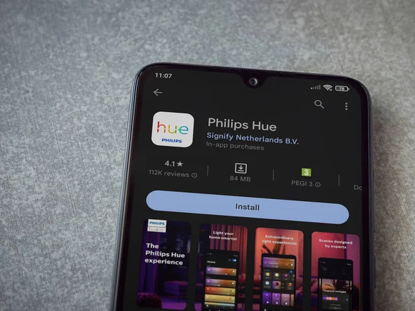 Lod, Israel - July 16,2023: Philips Hue app play store page on smartphone on ceramic stone background. Top view flat lay with copy space.