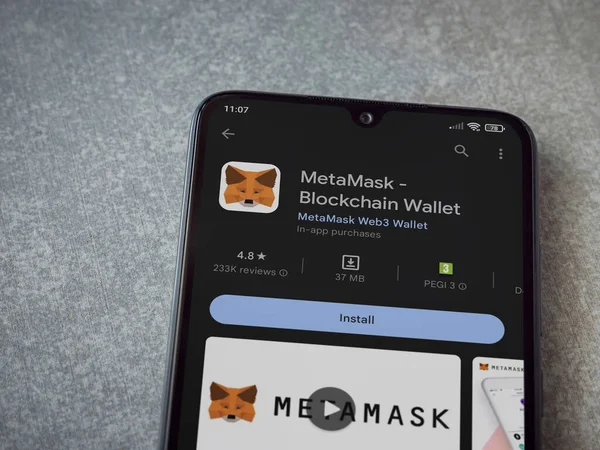 Lod, Israel - July 16,2023: MetaMask app play store page on smartphone on ceramic stone background. Top view flat lay with copy space.