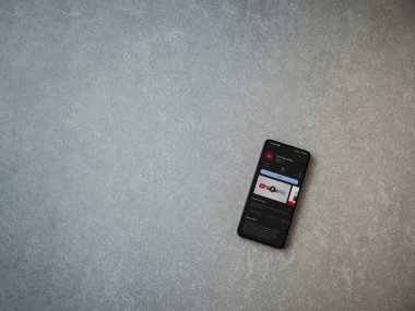 Lod, Israel - July 16,2023: YouTube Kids app play store page on smartphone on ceramic stone background. Top view flat lay with copy space.