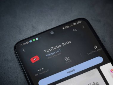 Lod, Israel - July 16,2023: YouTube Kids app play store page on smartphone on a dark marble stone background. Top view flat lay with copy space.