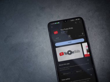 Lod, Israel - July 16,2023: YouTube Kids app play store page on smartphone on a dark marble stone background. Top view flat lay with copy space.