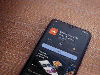 Lod, Israel - July 16,2023: SoundCloud app play store page on smartphone on wooden background. Top view flat lay with copy space.