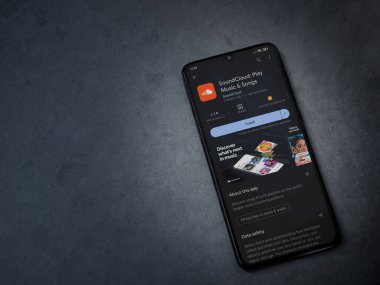 Lod, Israel - July 16,2023: SoundCloud app play store page on smartphone on a dark marble stone background. Top view flat lay with copy space.