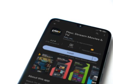 Lod, Israel - July 16,2023: Plex app play store page on smartphone on white background. Top view flat lay with copy space.