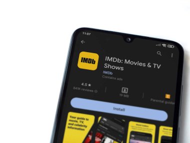 Lod, Israel - July 16,2023: IDMb app play store page on smartphone on white background. Top view flat lay with copy space.