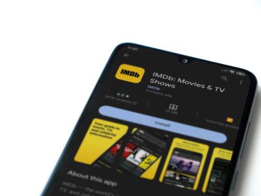 Lod, Israel - July 16,2023: IDMb app play store page on smartphone on white background. Top view flat lay with copy space.