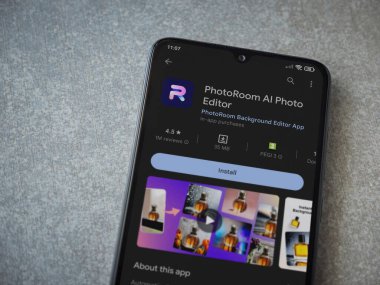 Lod, Israel - July 16,2023: PhotoRoom Studio Photo Editor app play store page on smartphone on ceramic stone background.. Top view flat lay with copy space.