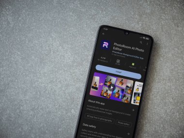 Lod, Israel - July 16,2023: PhotoRoom Studio Photo Editor app play store page on smartphone on ceramic stone background.. Top view flat lay with copy space.