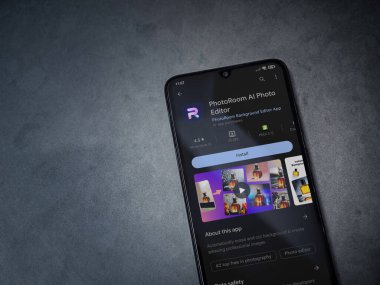 Lod, Israel - July 16,2023: PhotoRoom Studio Photo Editor app play store page on smartphone on a dark marble stone background. Top view flat lay with copy space.