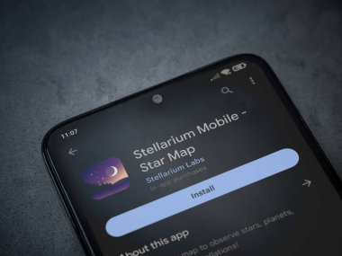 Lod, Israel - July 16,2023: Stellarium - Star Map app play store page on smartphone on a dark marble stone background. Top view flat lay with copy space.