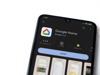 Lod, Israel - July 16,2023: Google Home app play store page on smartphone on white background. Top view flat lay with copy space.