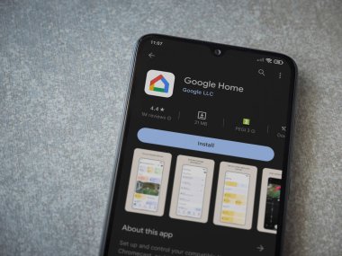 Lod, Israel - July 16,2023: Google Home app play store page on smartphone on ceramic stone background. Top view flat lay with copy space.
