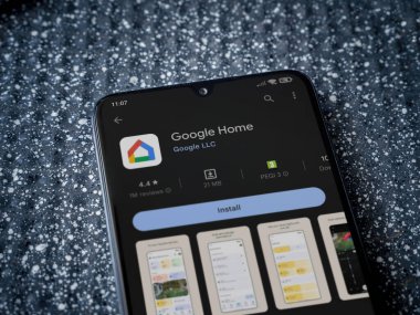 Lod, Israel - July 16,2023: Google Home app play store page on smartphone on a metallic background. Close up top view flat lay.