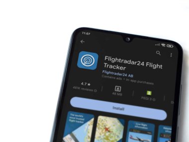 Lod, Israel - July 16,2023: Flightradar24 Flight Tracker app play store page on smartphone on white background. Top view flat lay with copy space.