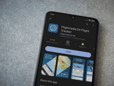 Lod, Israel - July 16,2023: Flightradar24 Flight Tracker app play store page on smartphone on ceramic stone background. Top view flat lay with copy space.