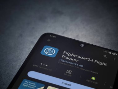 Lod, Israel - July 16,2023: Flightradar24 Flight Tracker app play store page on smartphone on a dark marble stone background. Top view flat lay with copy space.